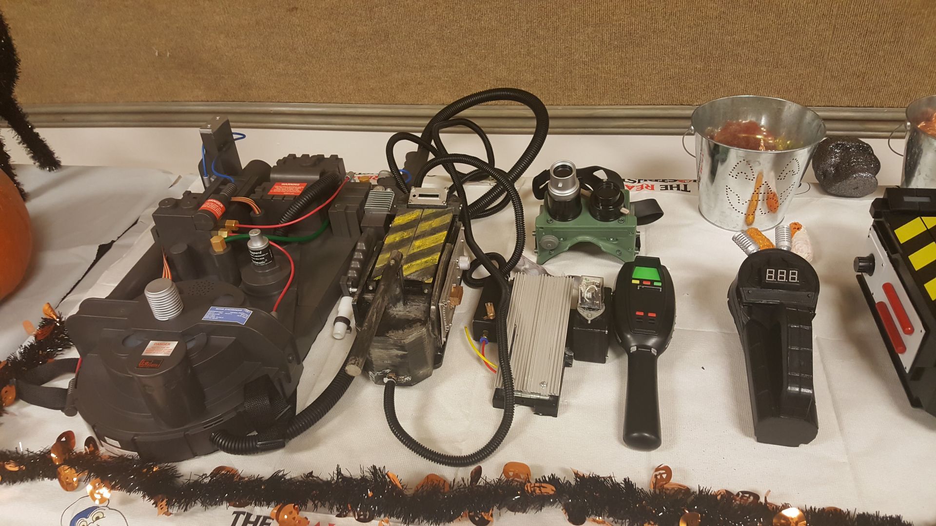 Assortment of handheld electronics and devices arranged on a countertop, with cables and tools nearby.