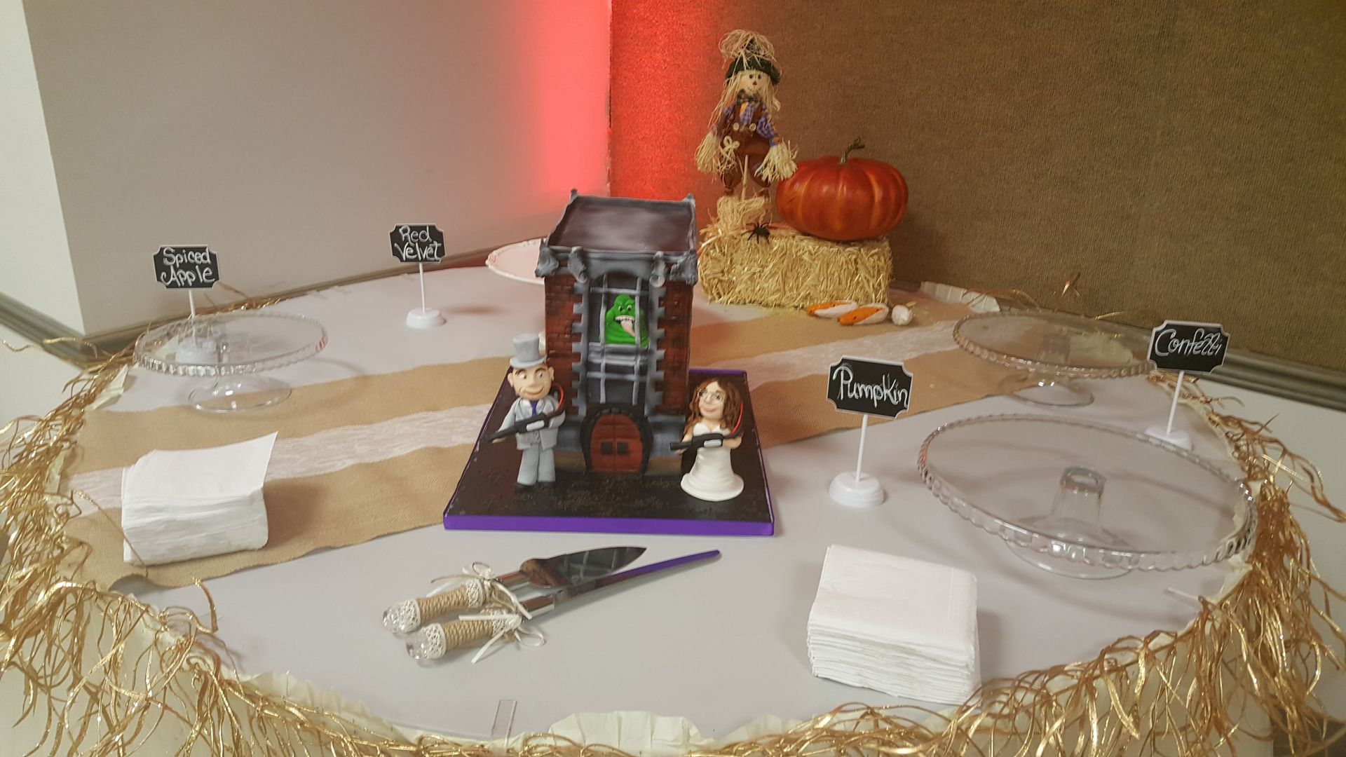 Miniature Halloween graveyard scene with tombstones, a pumpkin, skulls, and a small spooky house on a table