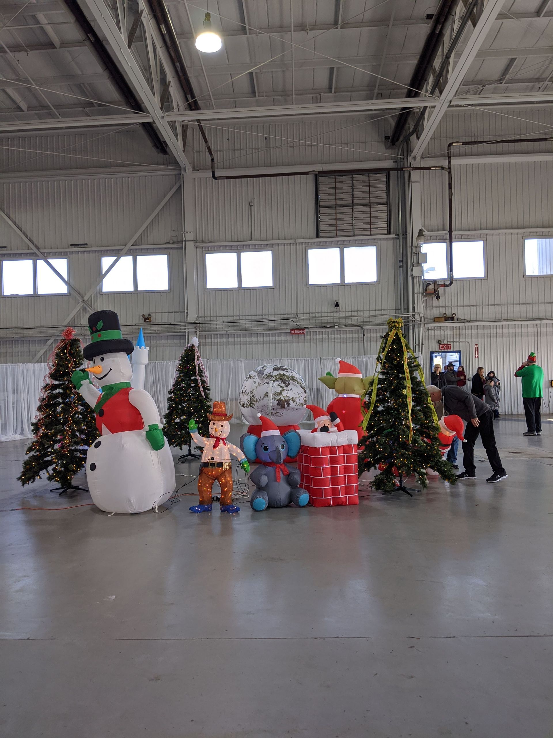 Holiday display of snowmen and decorated Christmas trees in a large indoor hall