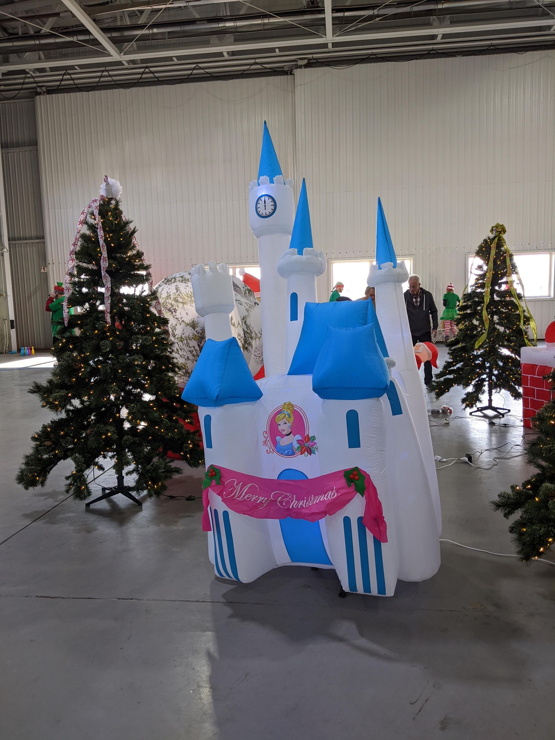 Decorated cardboard castle with blue turrets and Christmas trees in a festive indoor hall