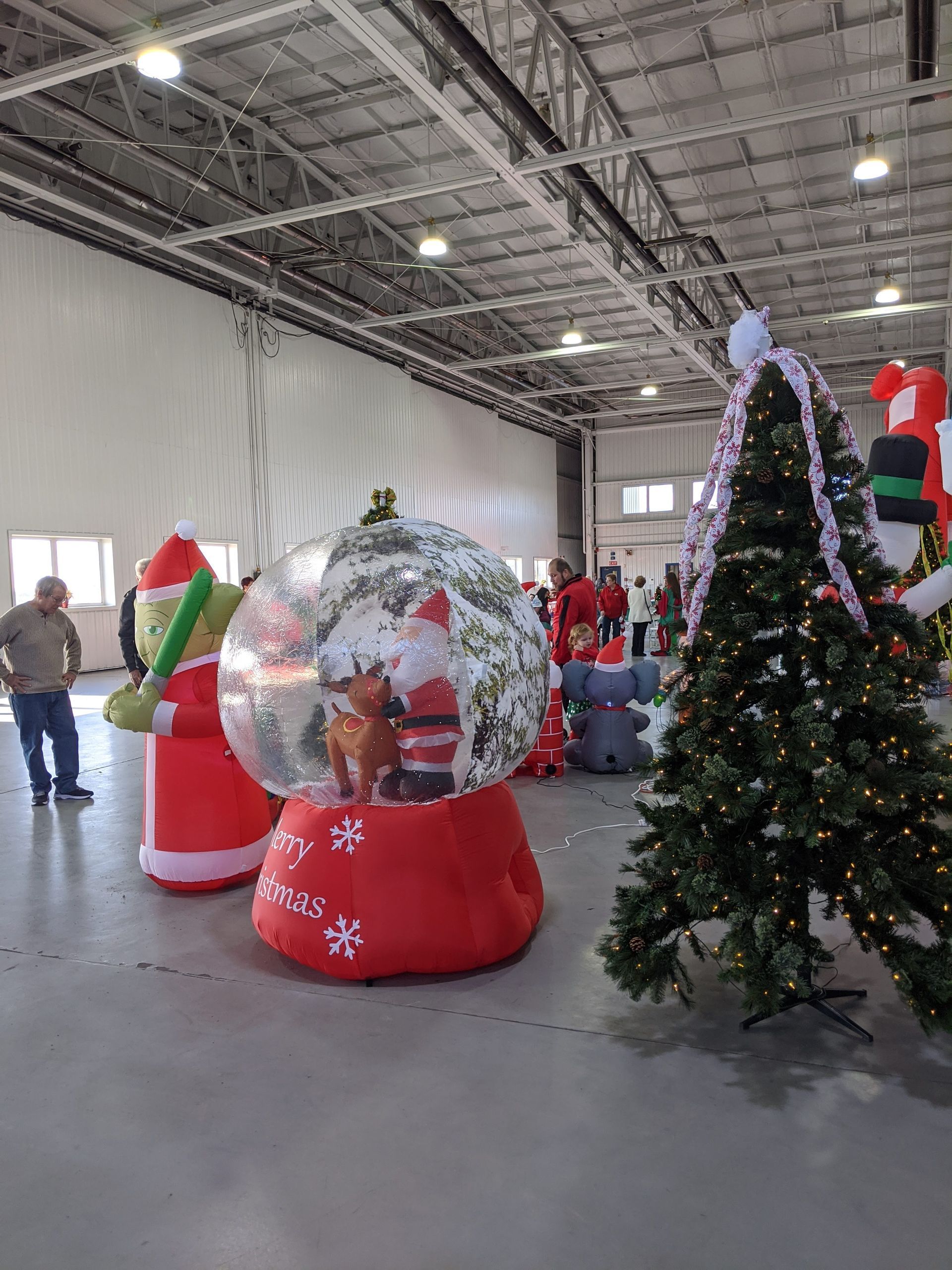 Holiday display with Santa and snow globe decorations in a warehouse-like room