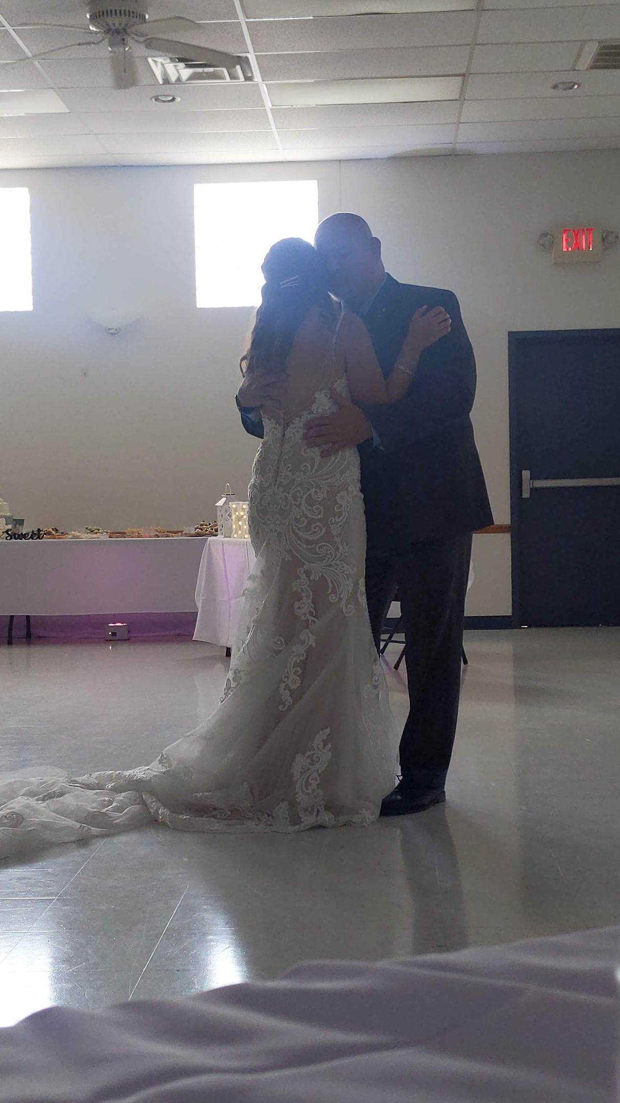 Bride and groom kissing on a dance floor in a softly lit reception hall