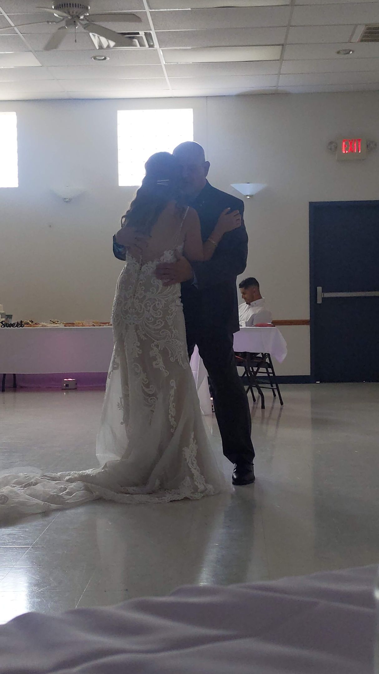 Bride and groom dancing in a bright hall at their wedding reception