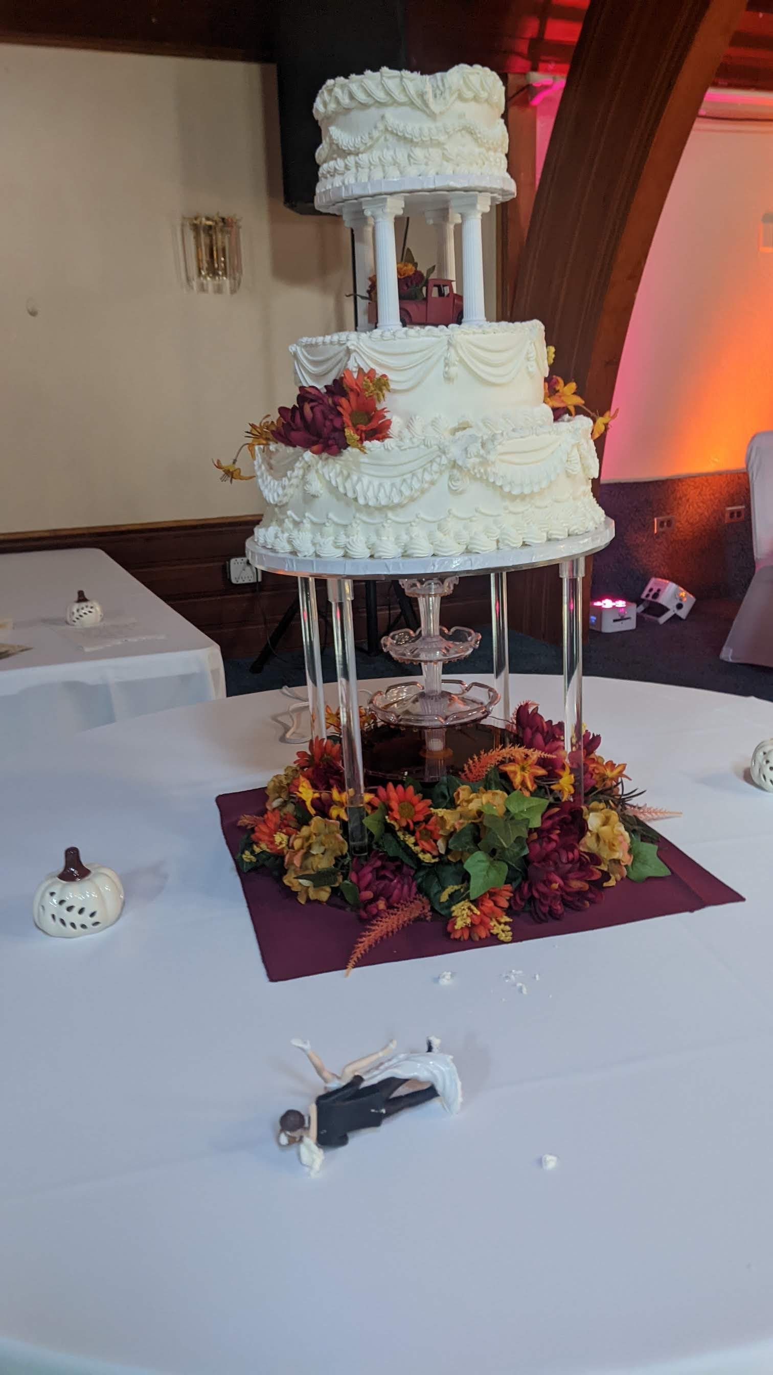Three-tier white wedding cake with floral decorations on a banquet table