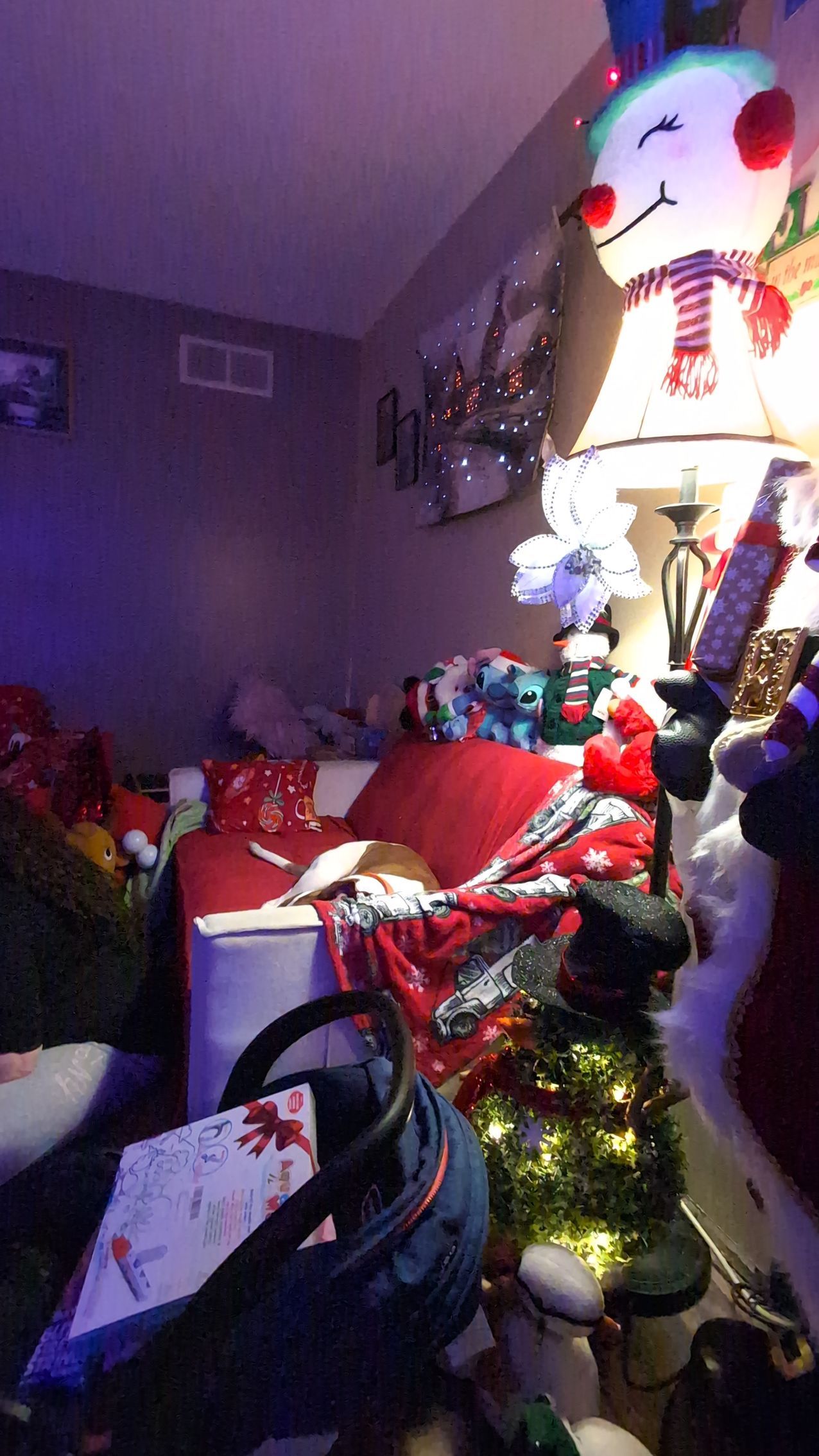 Festive living room with red holiday decor and a large illuminated snowman decoration