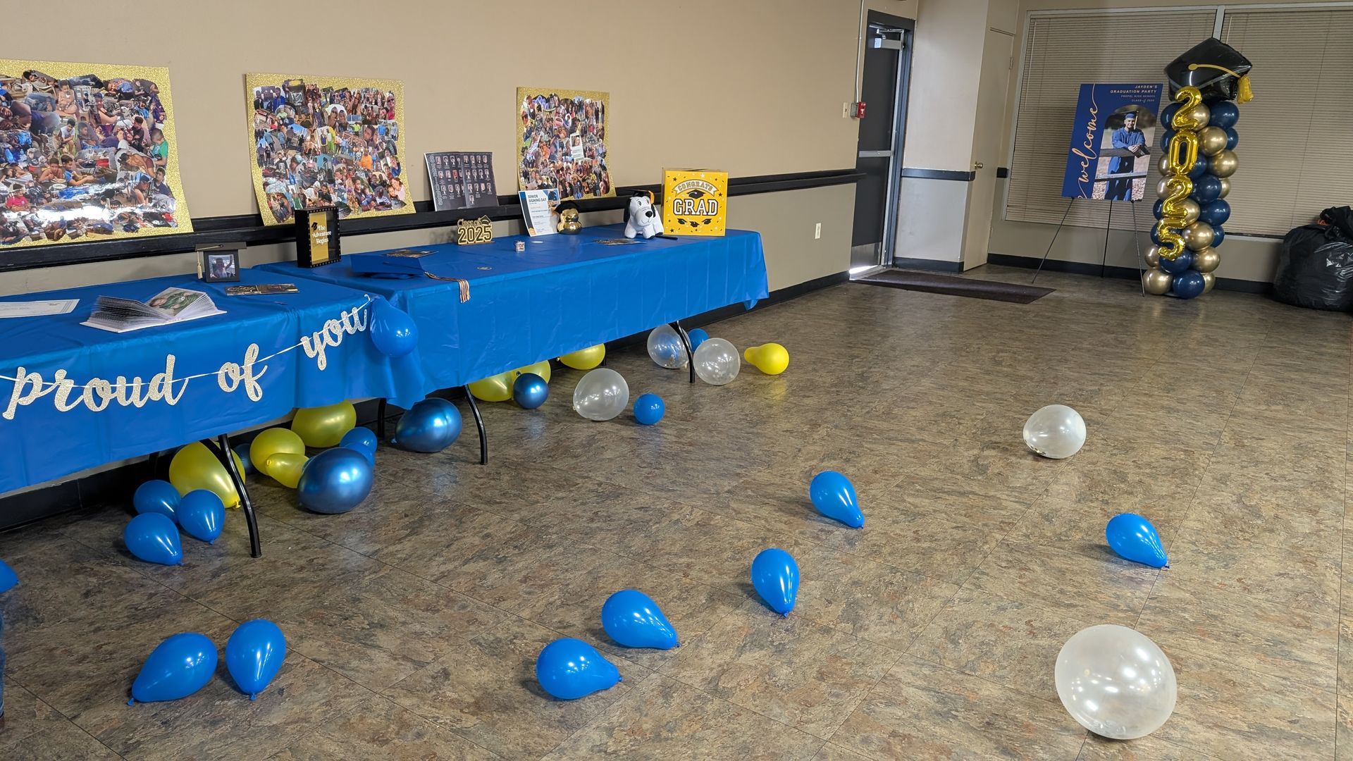 Decorated room with blue balloons, a long table, and wall displays for a celebration or event