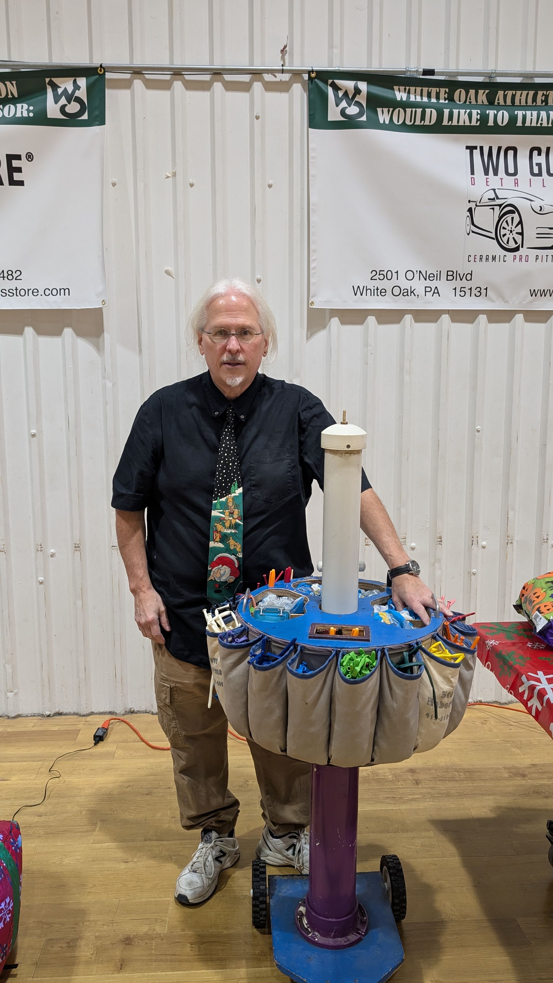 Person standing beside a colorful spinning prize wheel at an indoor event.