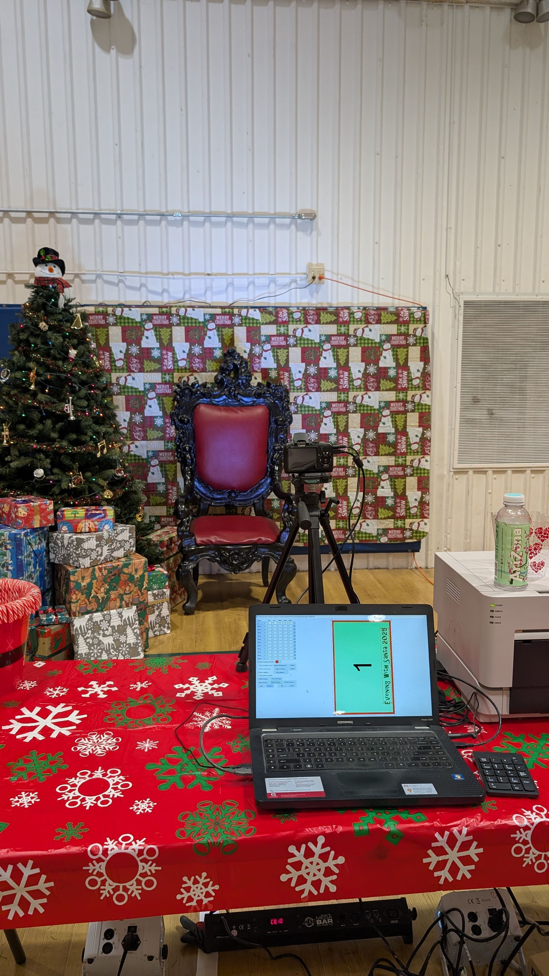 Festive room with Christmas tree, wrapped gifts, chair, laptop, and red snowflake tablecloth