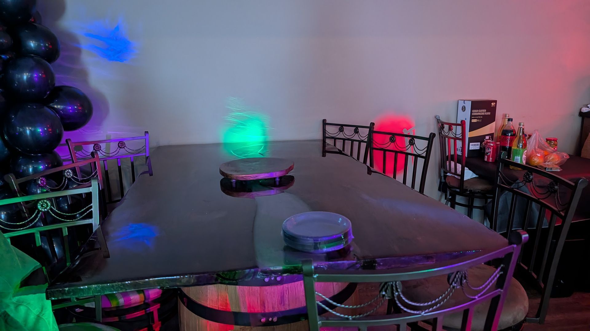Decorated room with balloons, glowing colored lights, tables, and a party setup