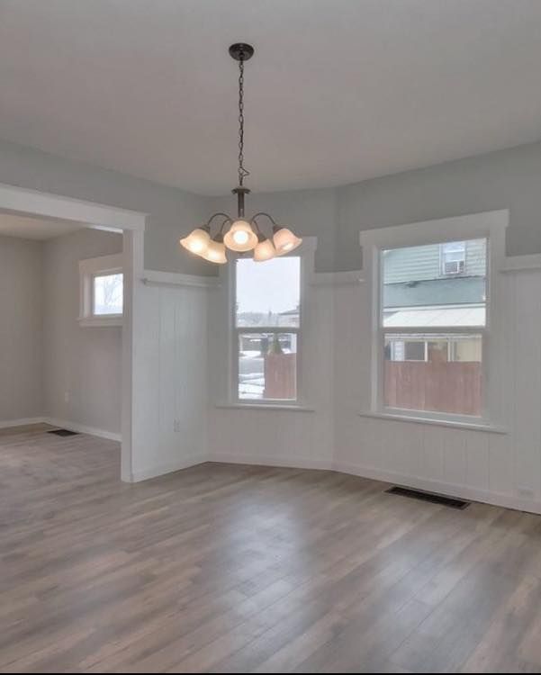 An empty room with a chandelier hanging from the ceiling