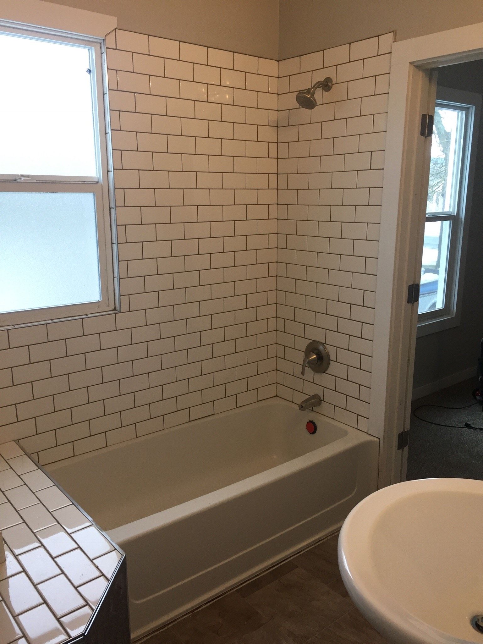 A bathroom with a tub a sink and a window