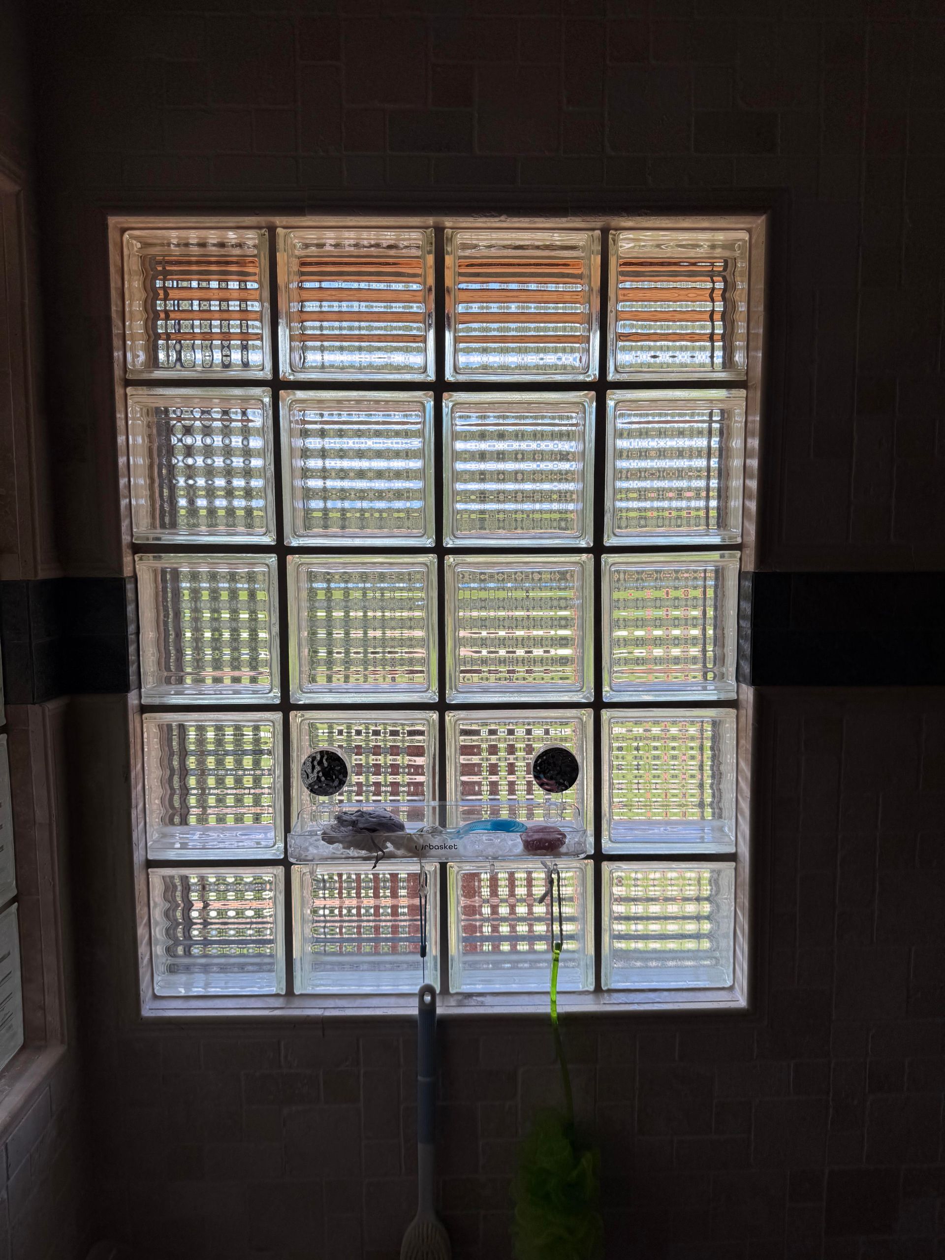 Glass block window with a door handle, letting light into a dim room