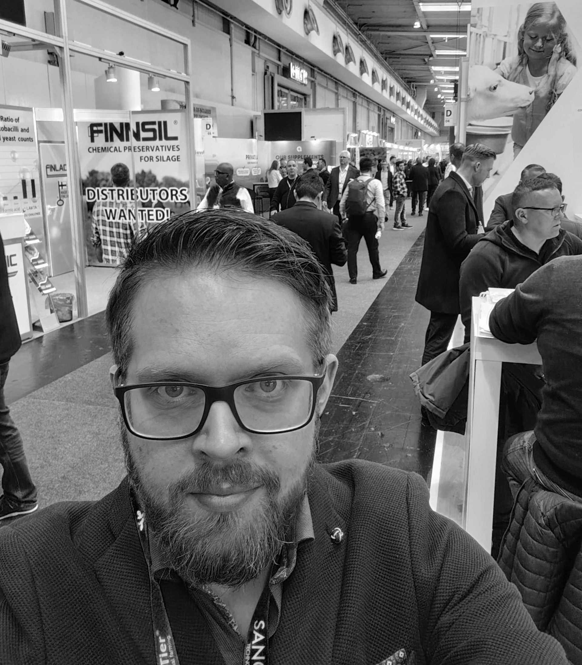 Mies ottaa selfien vilkkaalla sisätorin käytävällä, taustalla kojuja ja ostajia