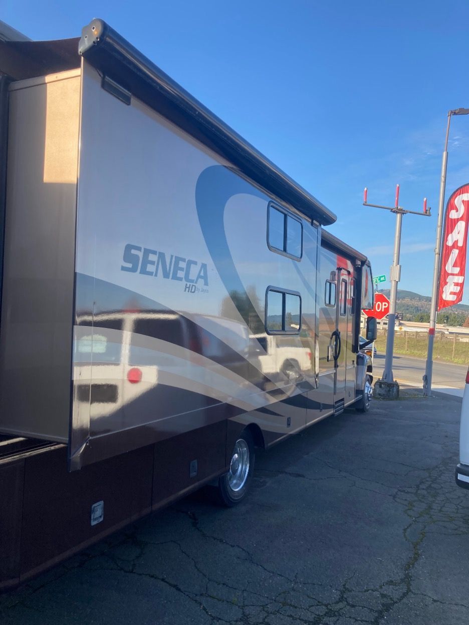Brown Seneca RV parked on a sunny day next to a
