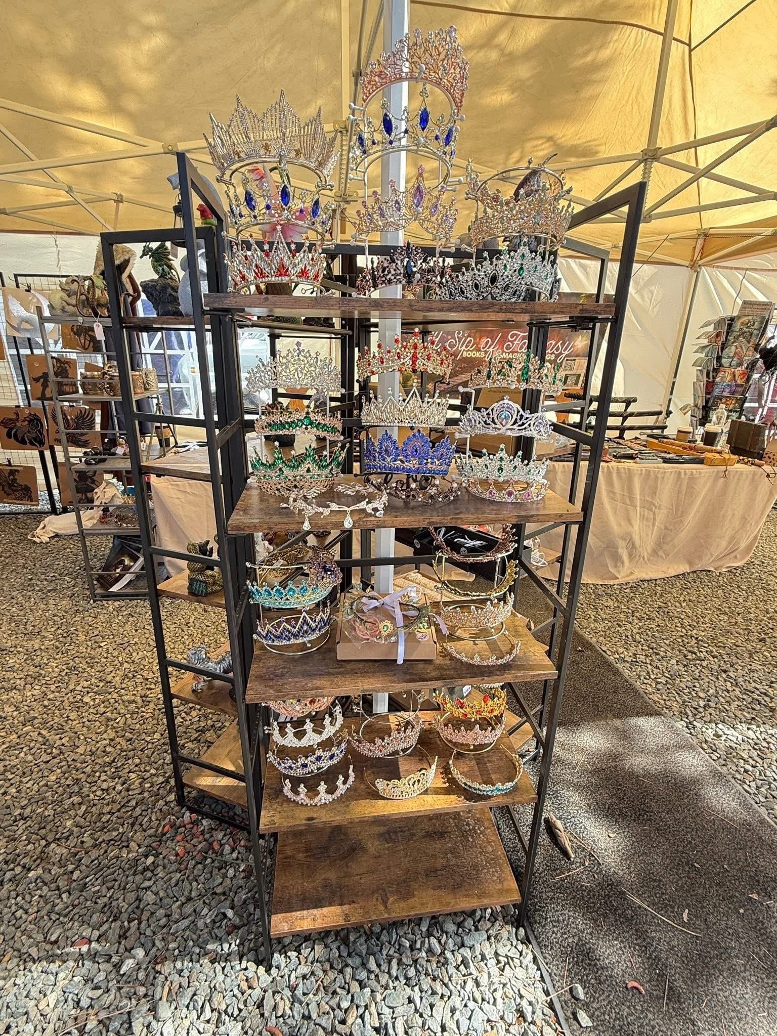 Metal display rack with jewelry and decorative items under a tent at an outdoor market