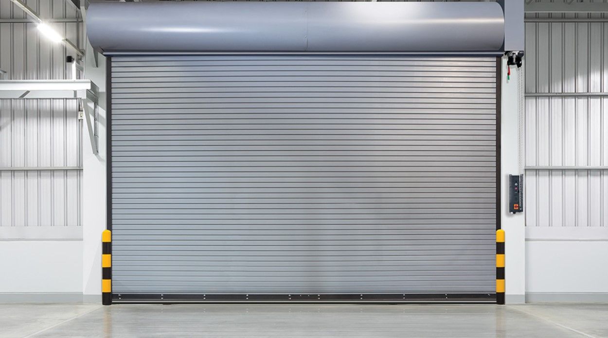 An empty warehouse with a gray roller shutter door.