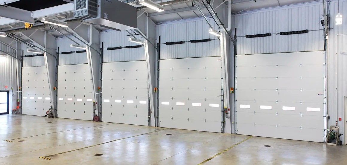 A large empty warehouse with a lot of white doors.