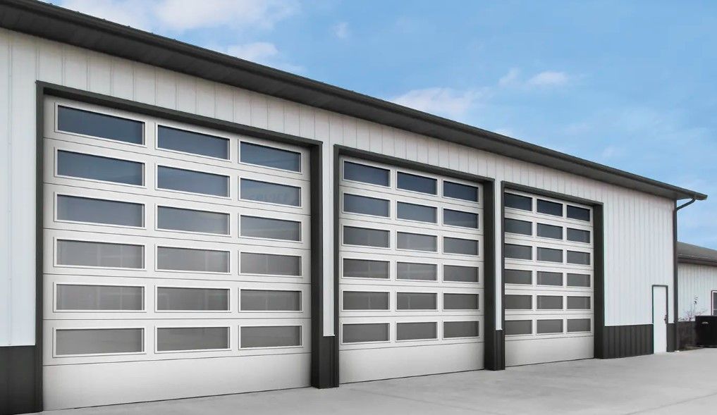 A row of garage doors on a building with a blue sky in the background.