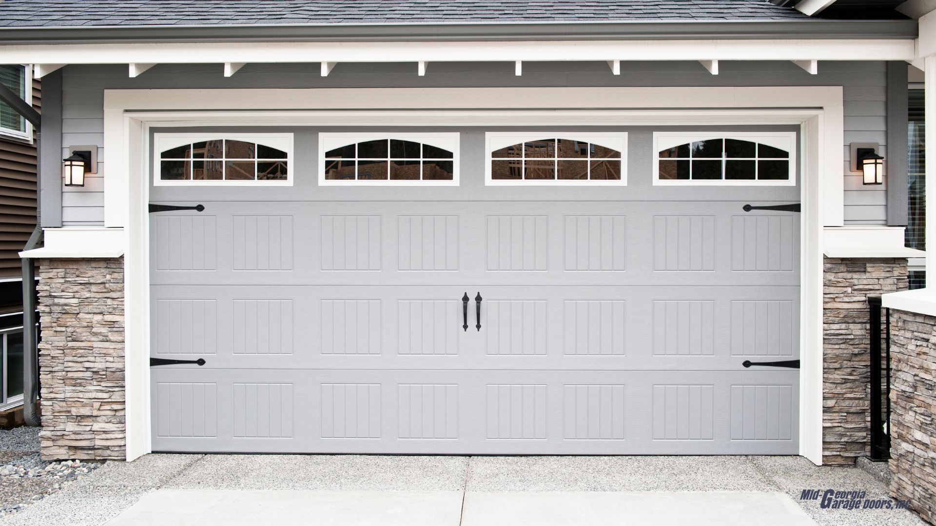 A gray garage door in Palmetto Ga is sitting in front of a house.