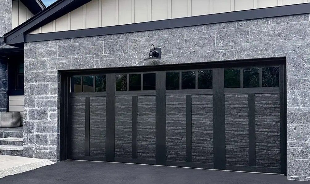 A black garage door is sitting in front of a brick house in Palmetto Ga.