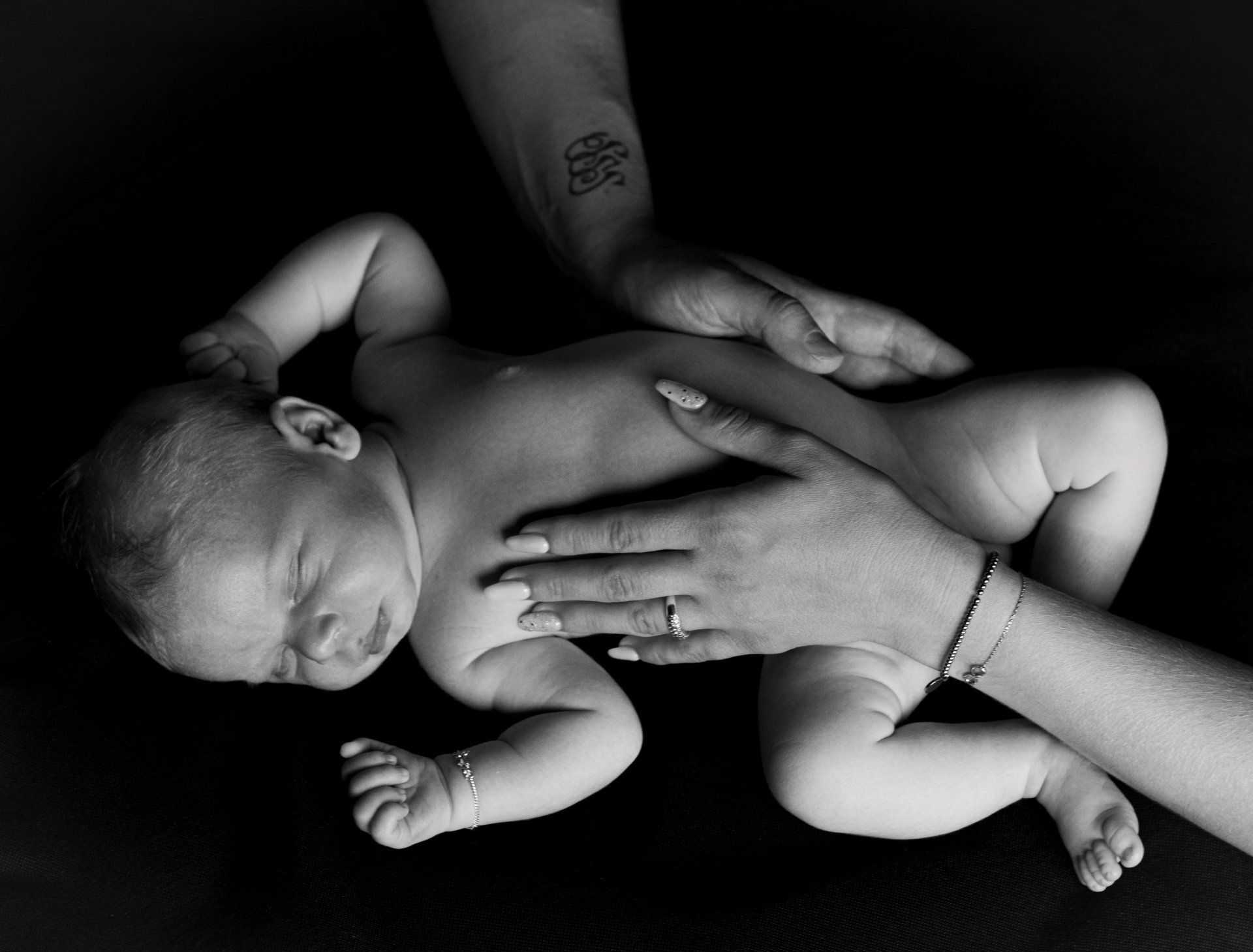 Een zwart-witfoto van een persoon die een pasgeboren baby vasthoudt