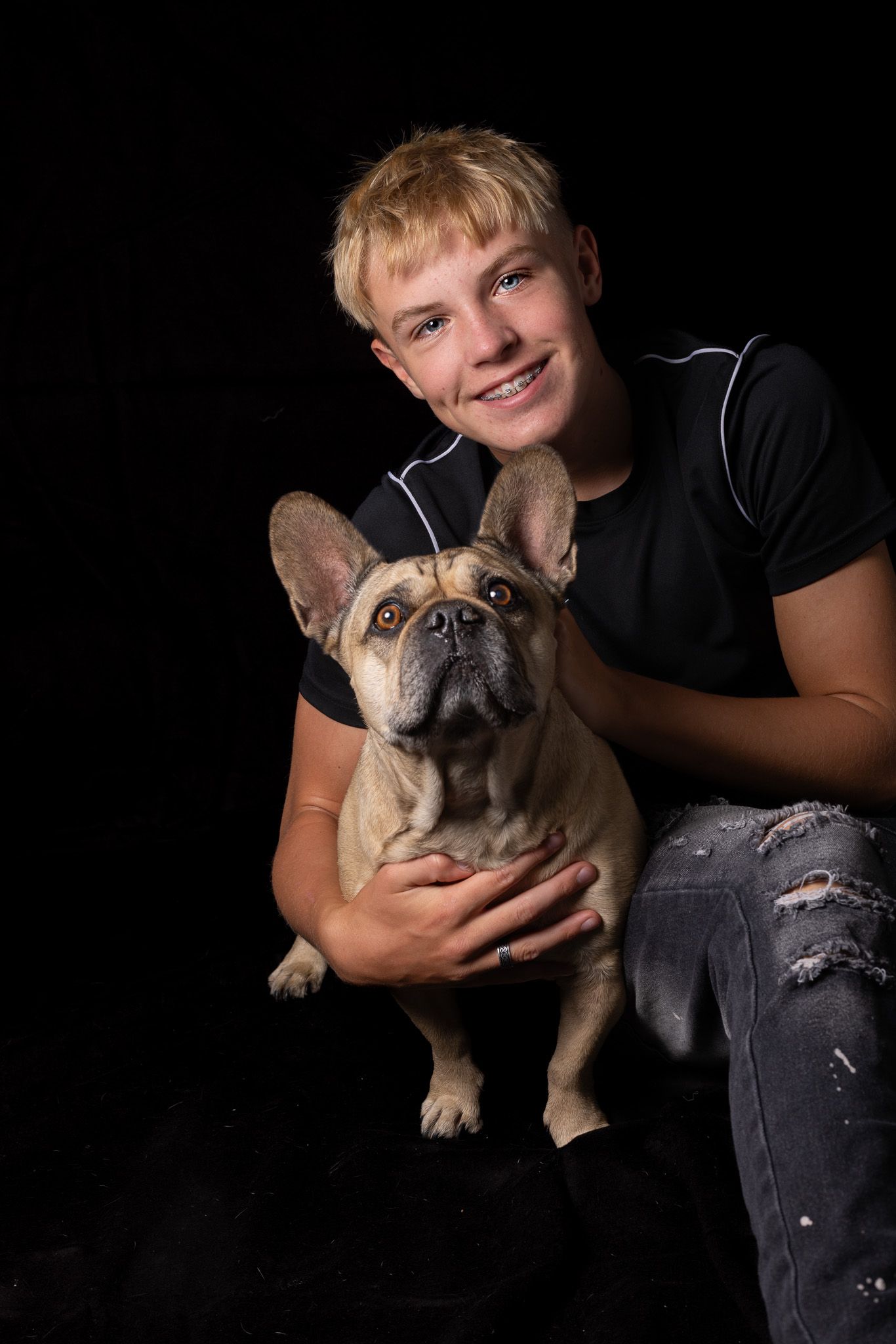 Een jonge man houdt een Franse bulldog in zijn armen.