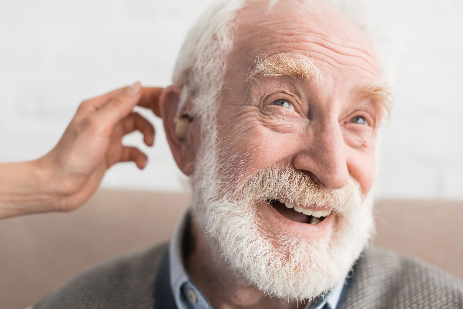 Mujer escuchando nuevamente gracias a uno de los audífonos para sordos Fotografía de un hombre de la tercera edad feliz por volver a escuchar con un audífono para sordo debido a la hipoacusia