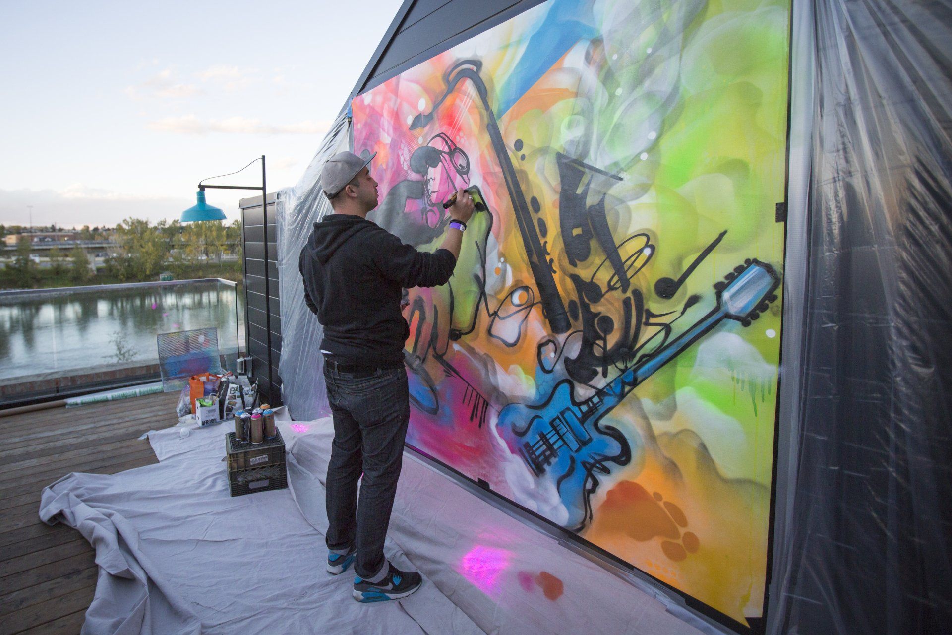 A man is painting a mural on a wall.