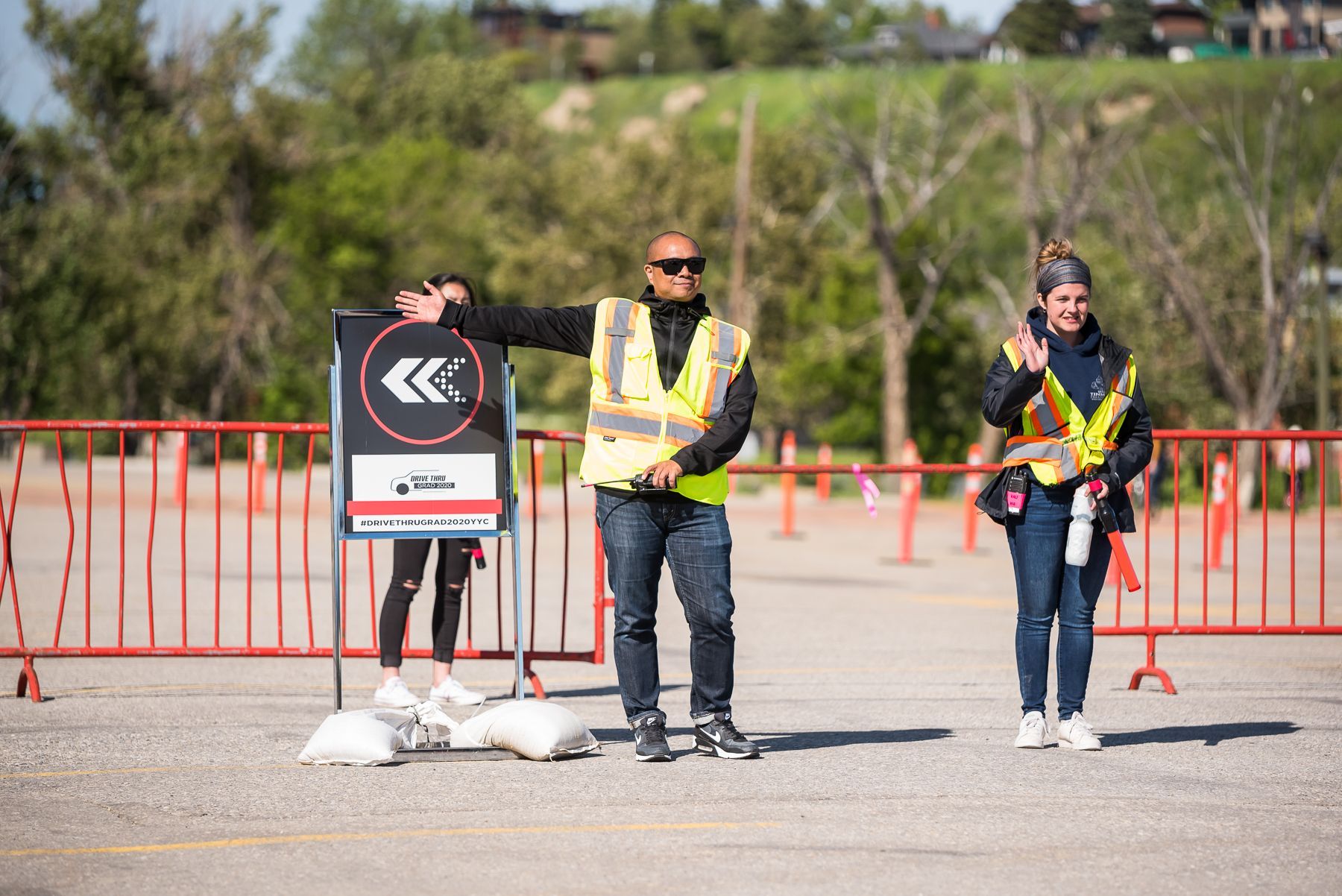 A man and a woman are standing next to a sign in a parking lot.