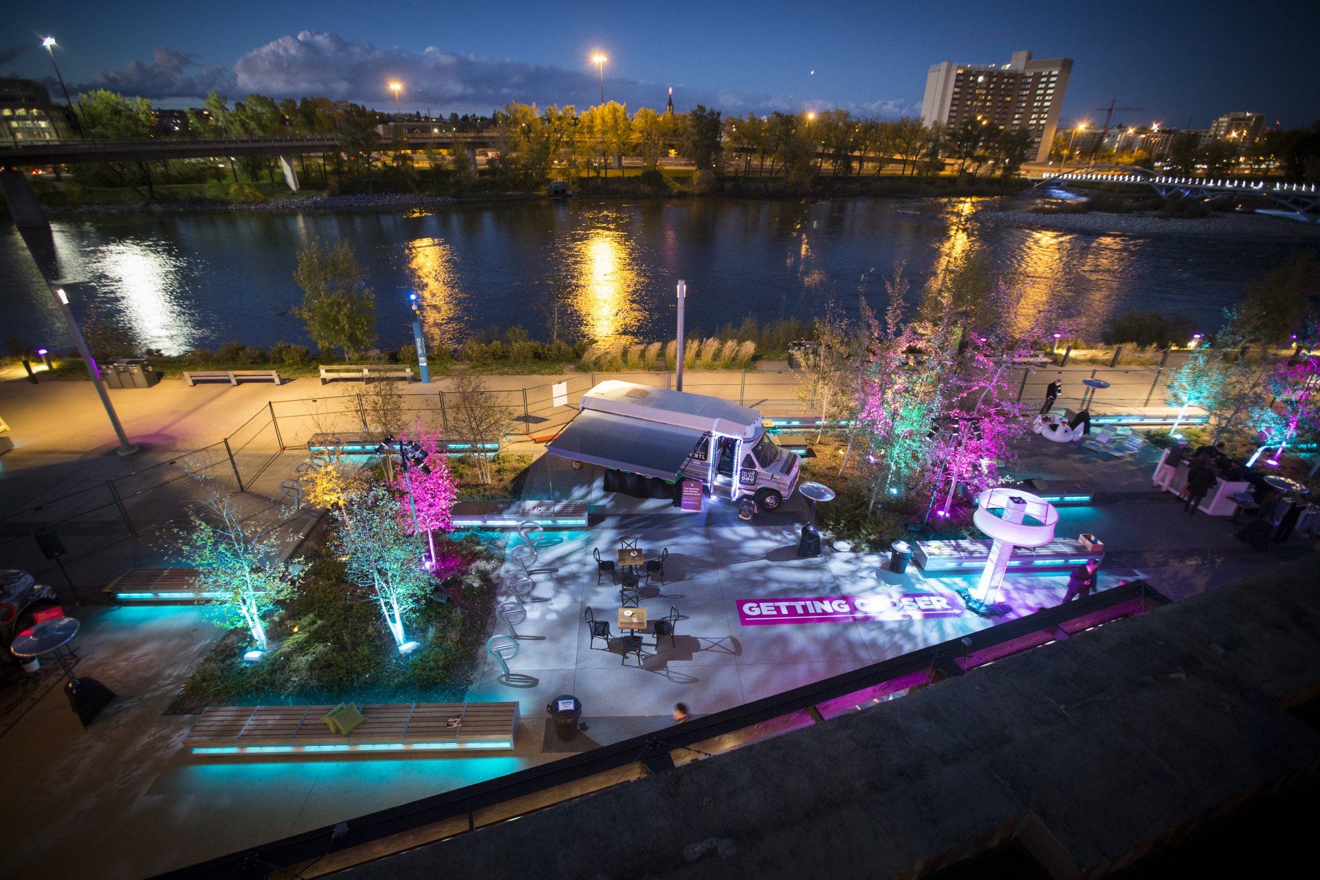 An aerial view of a stage in front of a river at night.