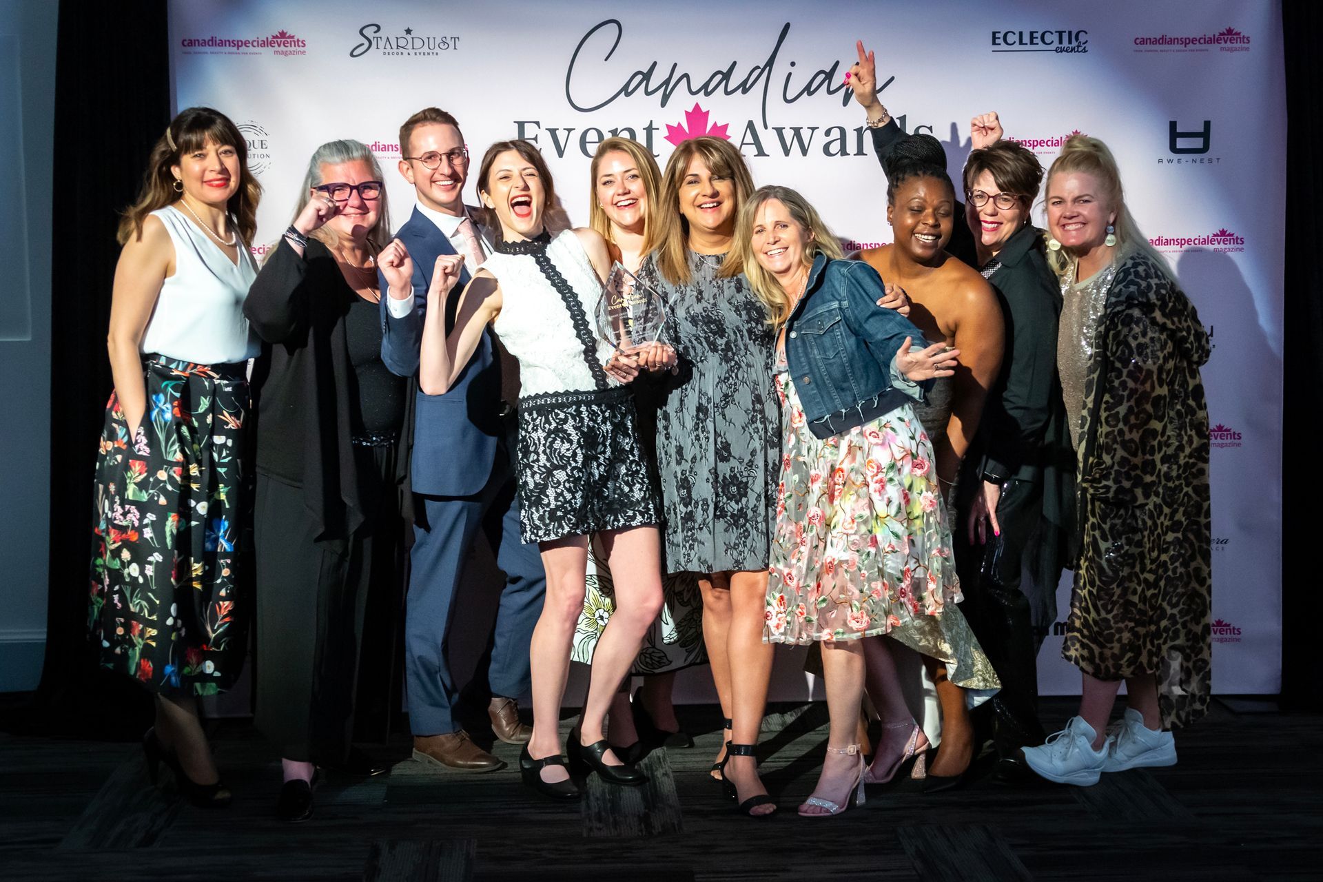 A group of women are posing for a picture while holding a trophy.