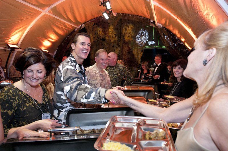A man shaking hands with a woman at a buffet