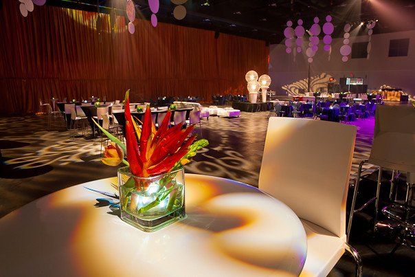 A table with a vase of flowers on it in a large room.