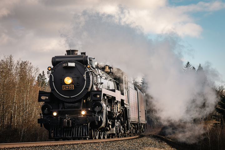 A train is going down the tracks with smoke coming out of it.