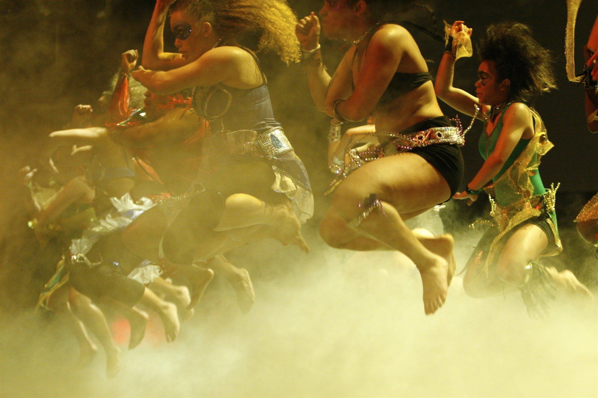 A group of women are jumping in the air on a stage.