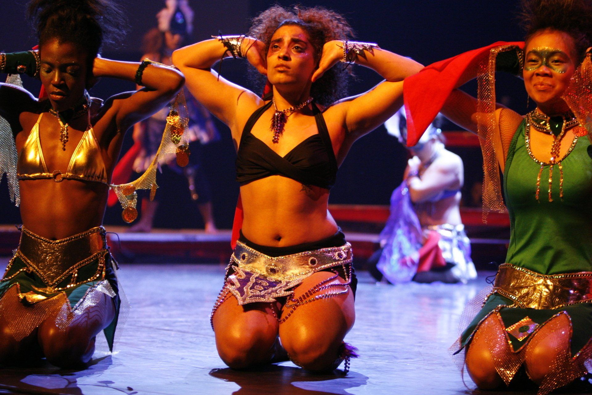 A group of women are kneeling down on a stage