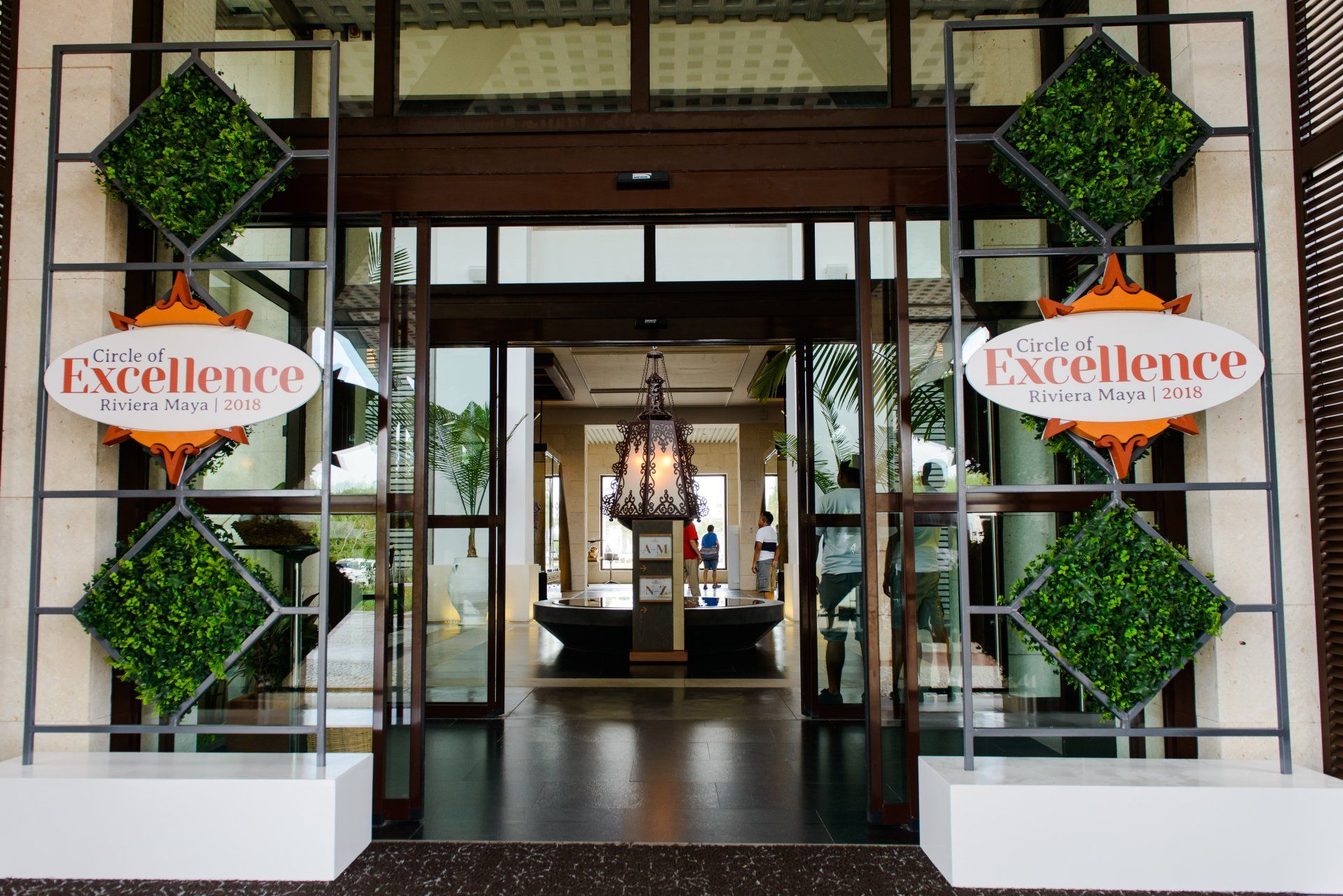 A hotel entrance with a sign that says excellence