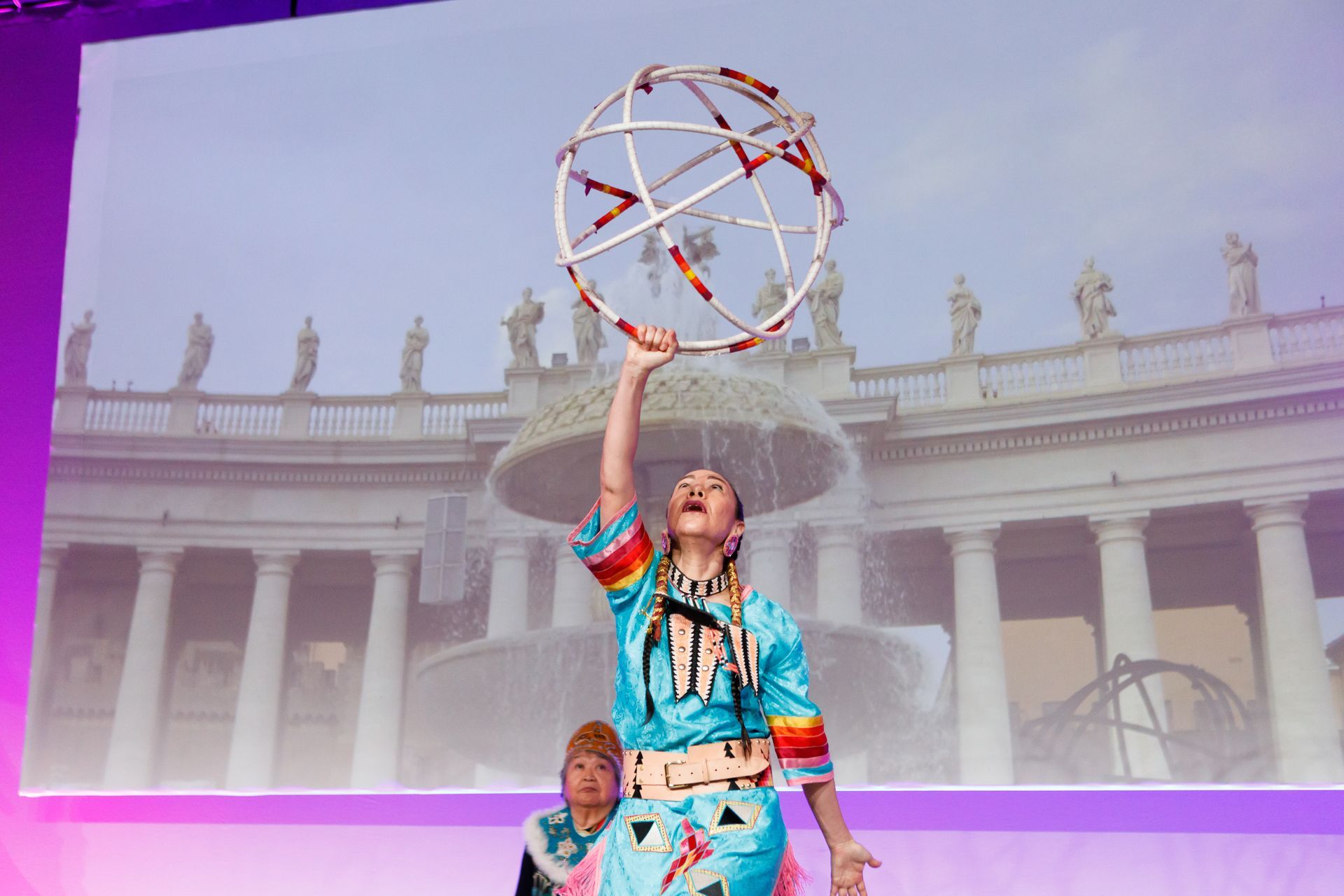 A woman is holding a hula hoop in front of a fountain.
