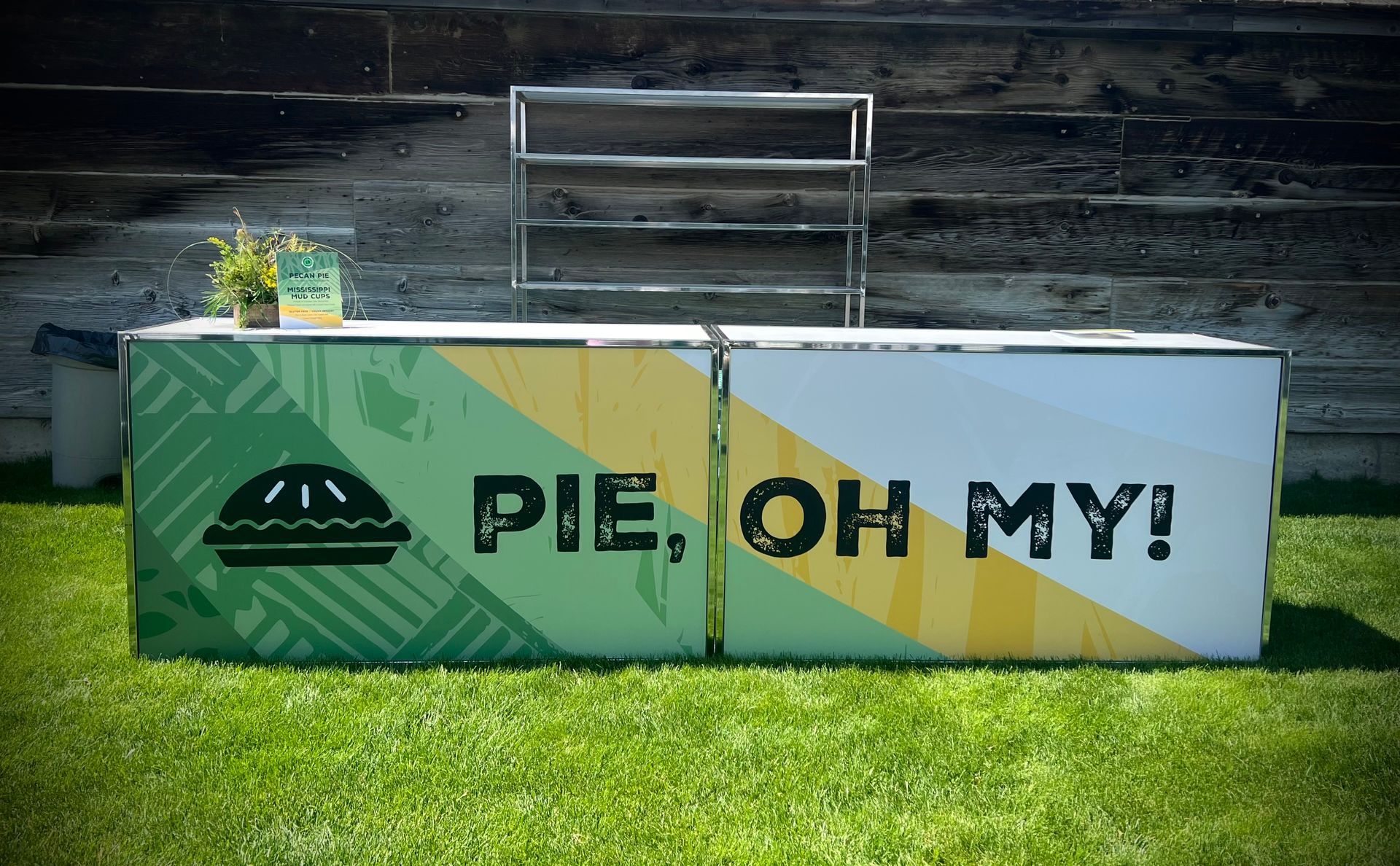 Pie vendor's booth on green grass with the text