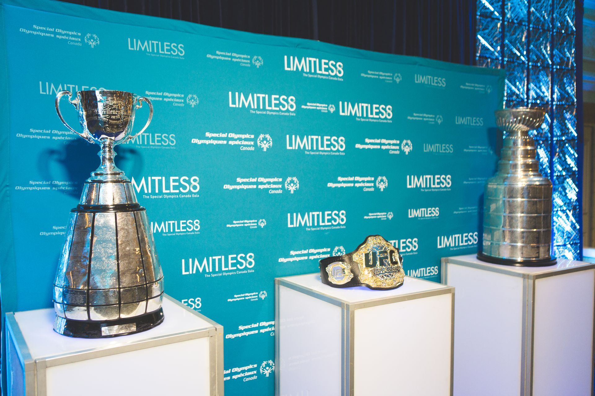 Two trophies are on display in front of a wall that says limitless