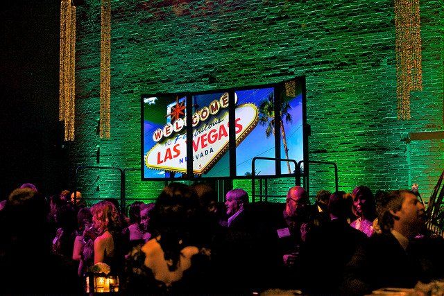 A group of people are sitting in front of a las vegas sign.