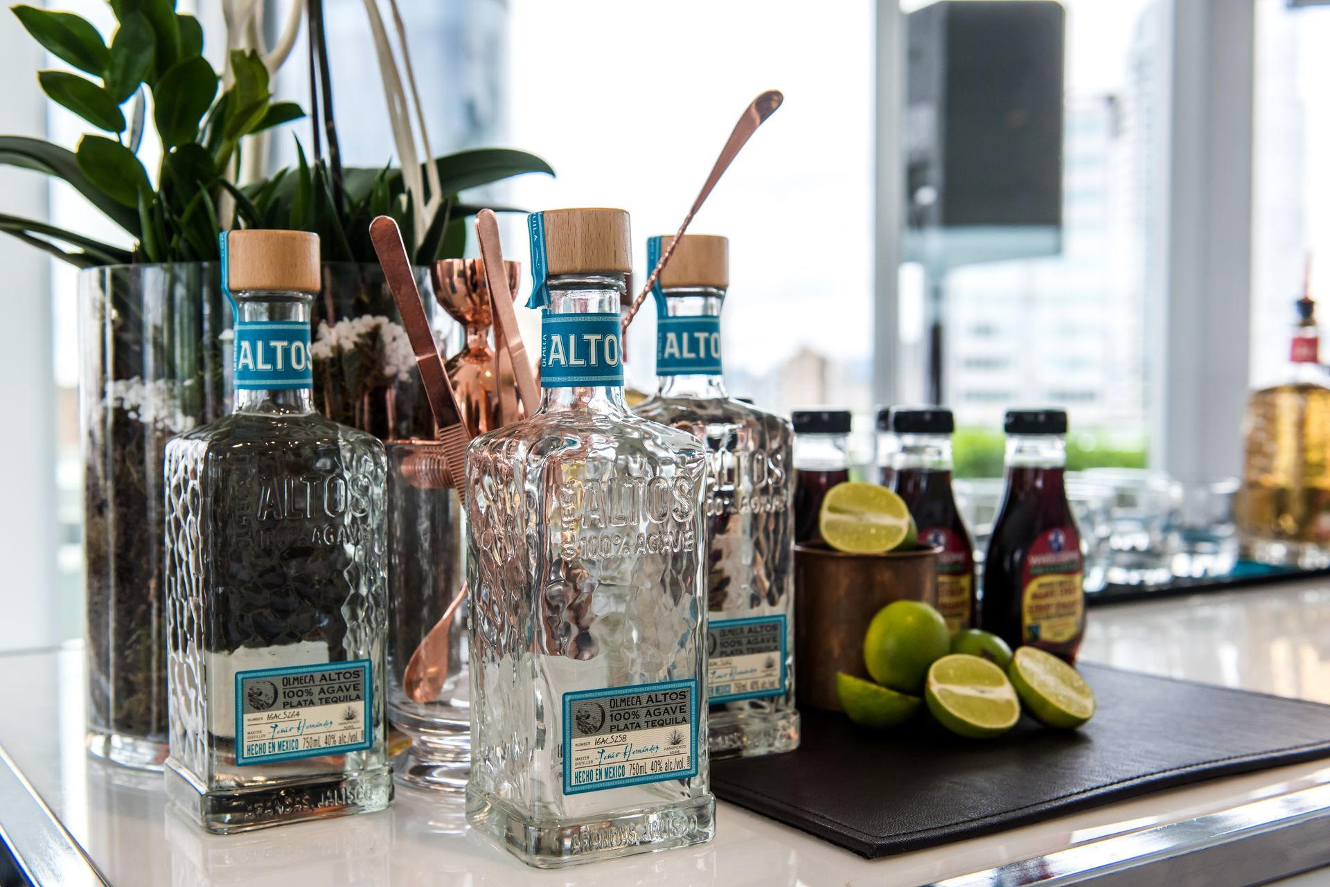A bar with bottles of alcohol and limes on it.