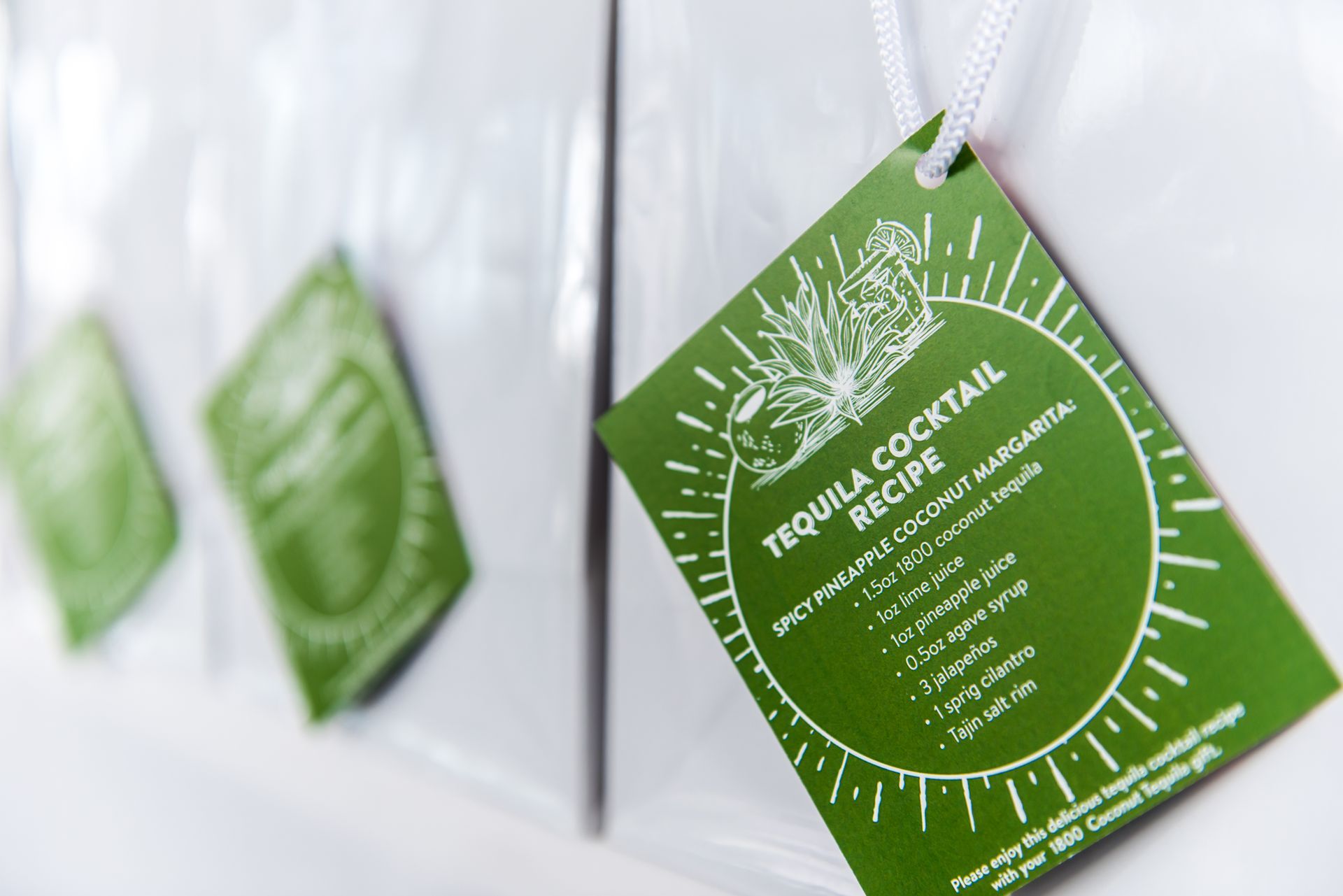 A green tag with a tequila cocktail recipe on it