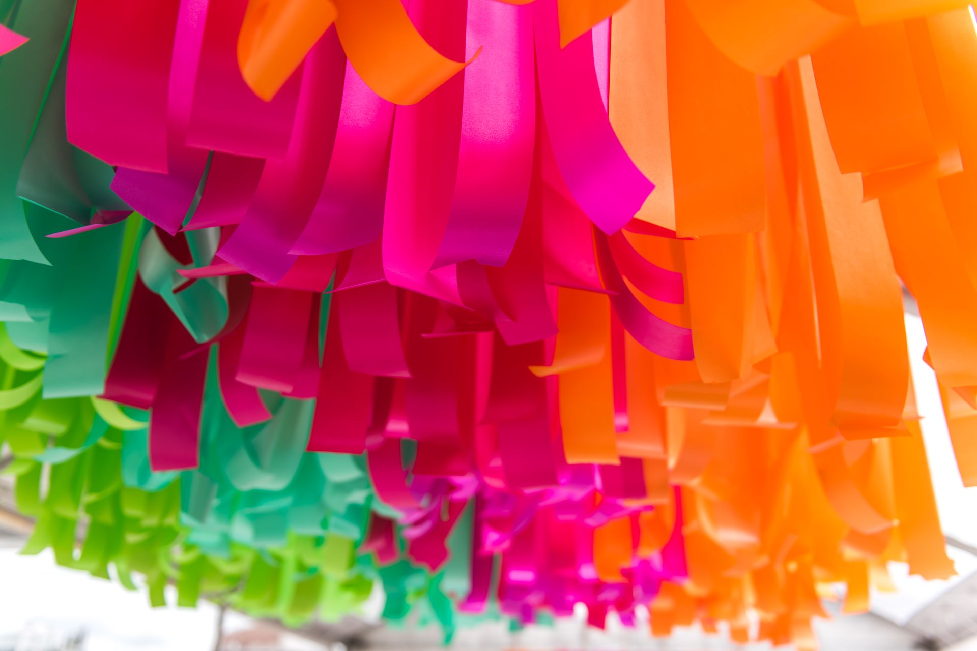 A bunch of colorful ribbons are hanging from the ceiling
