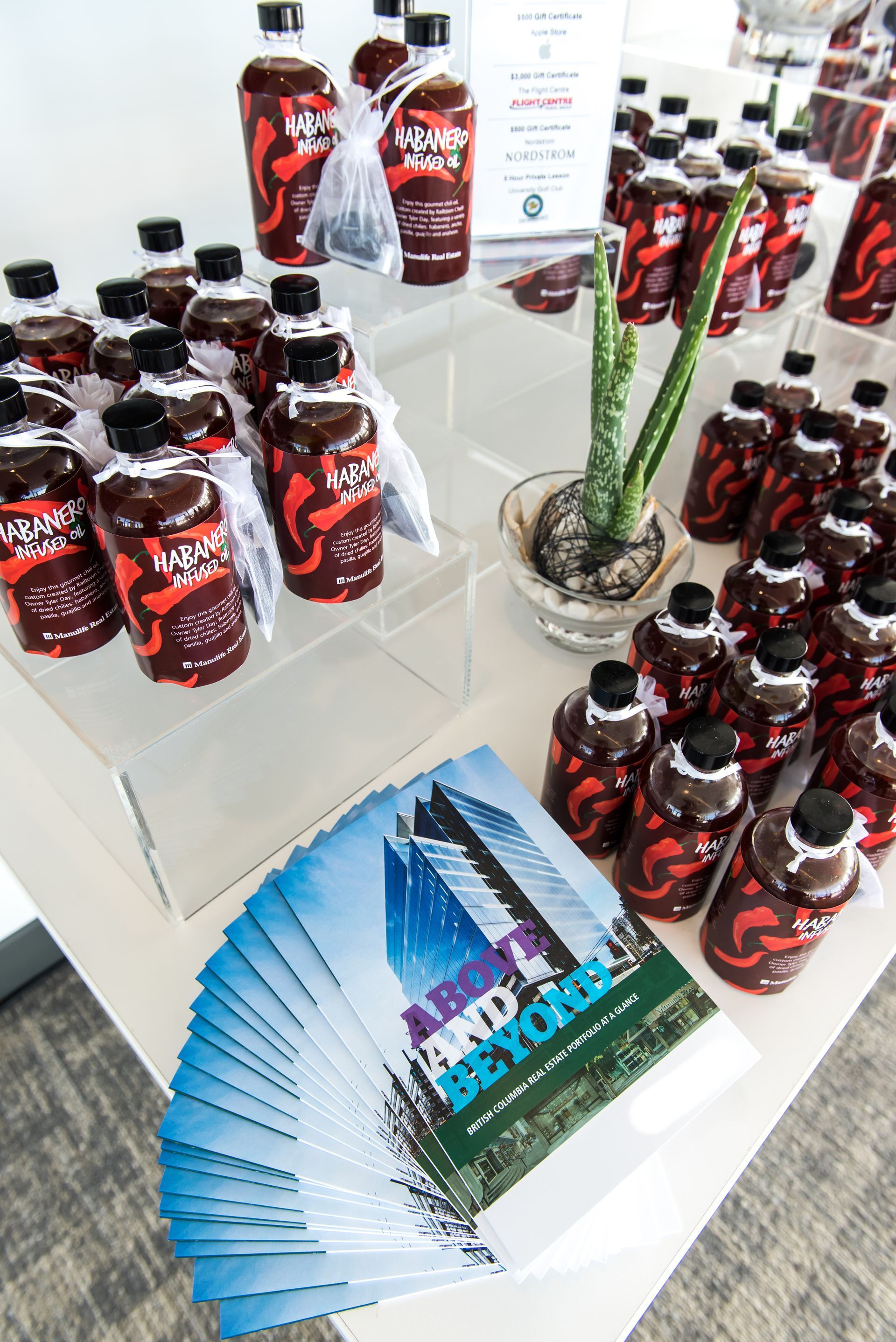 A table topped with bottles of hot sauce and a book.