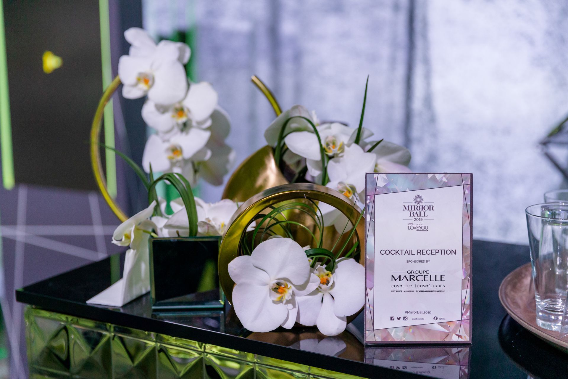 A table with flowers and a sign on it.