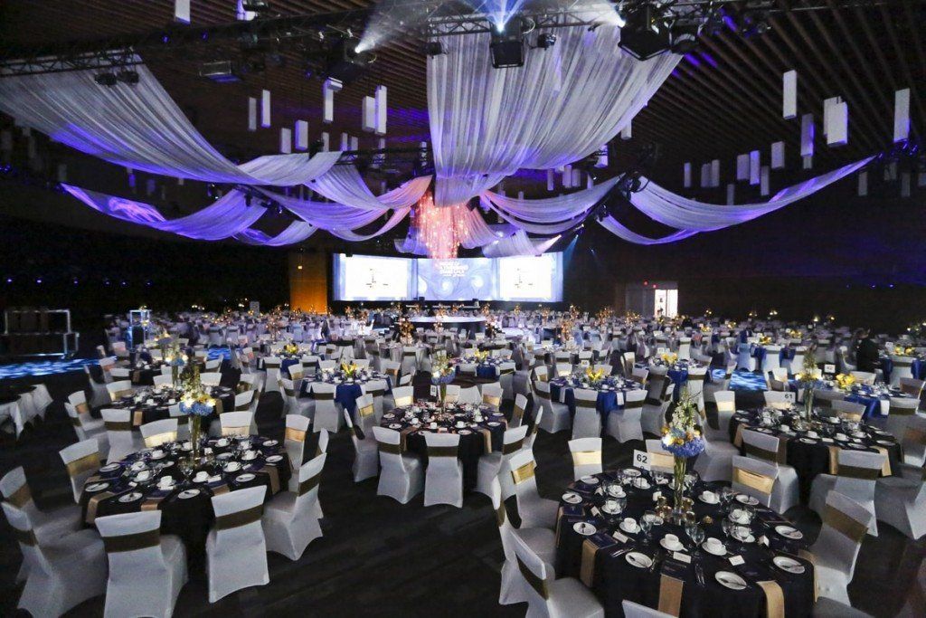 A large room with tables and chairs set up for a banquet