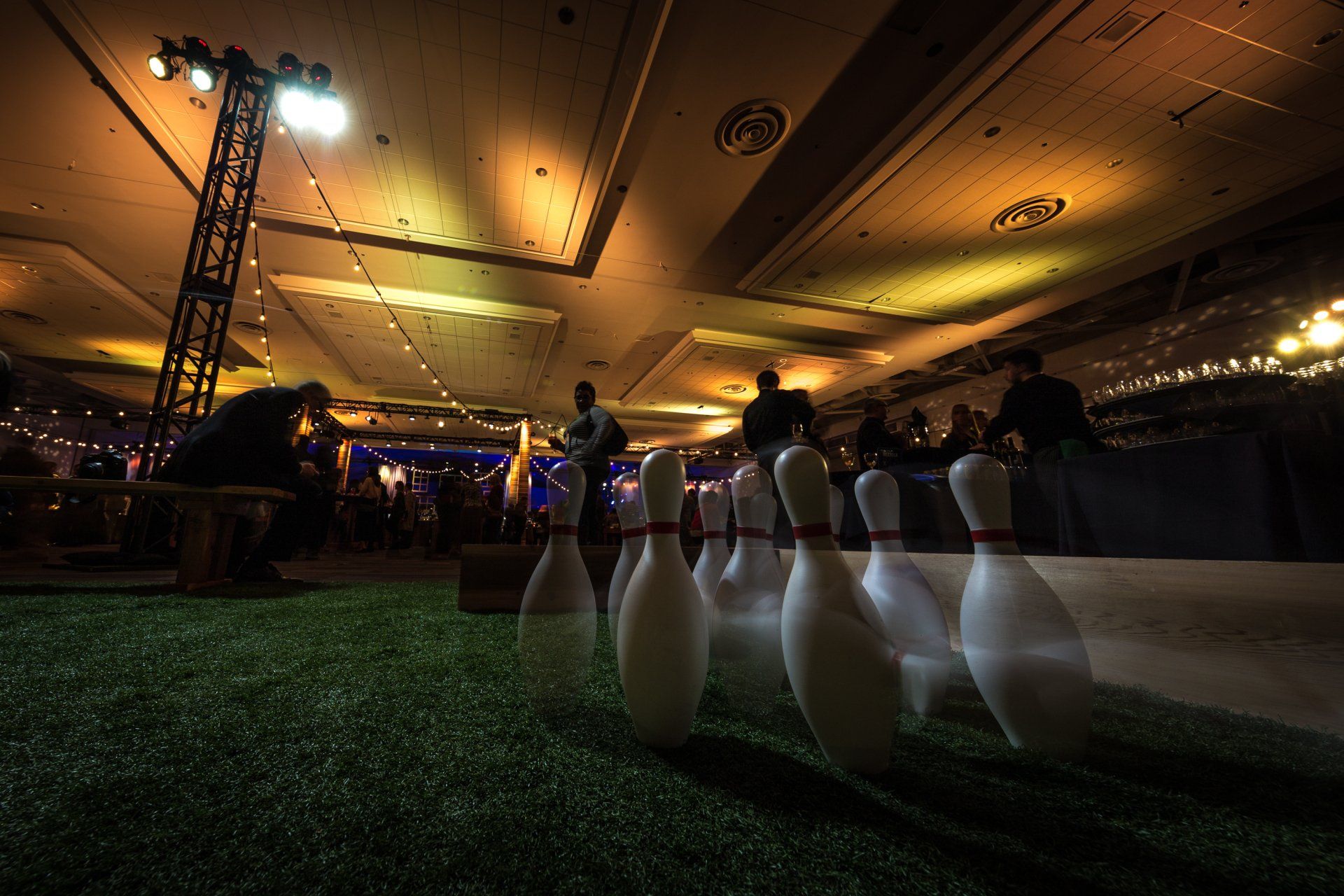 A bunch of bowling pins are lined up in a room