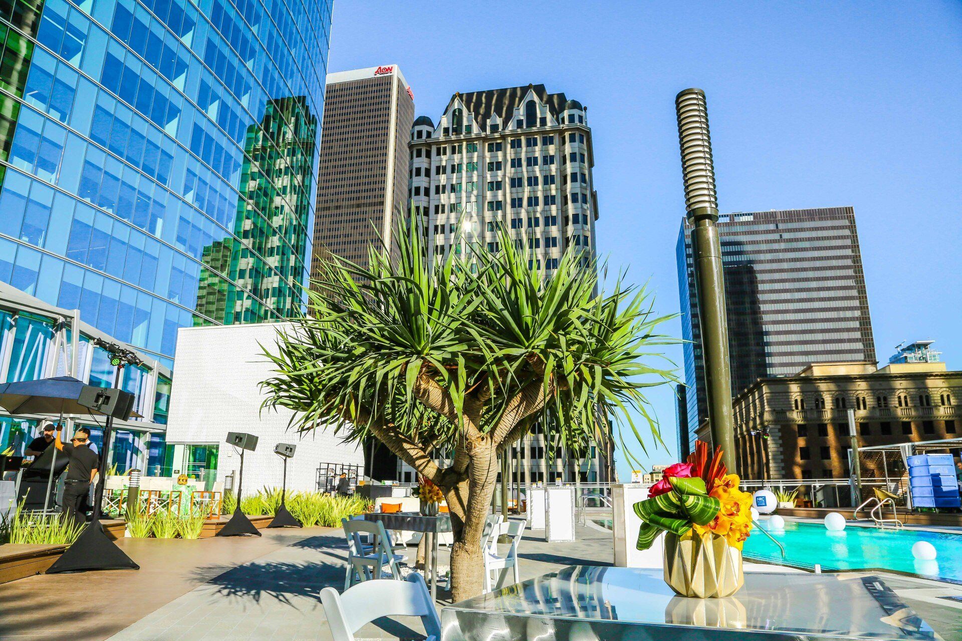 A table with a vase of flowers on it in front of a city skyline.