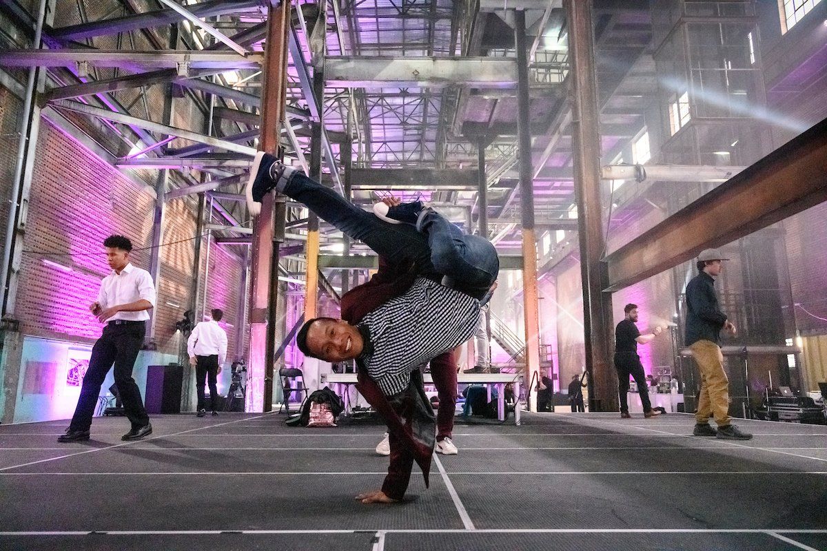 A man is doing a handstand in a building.